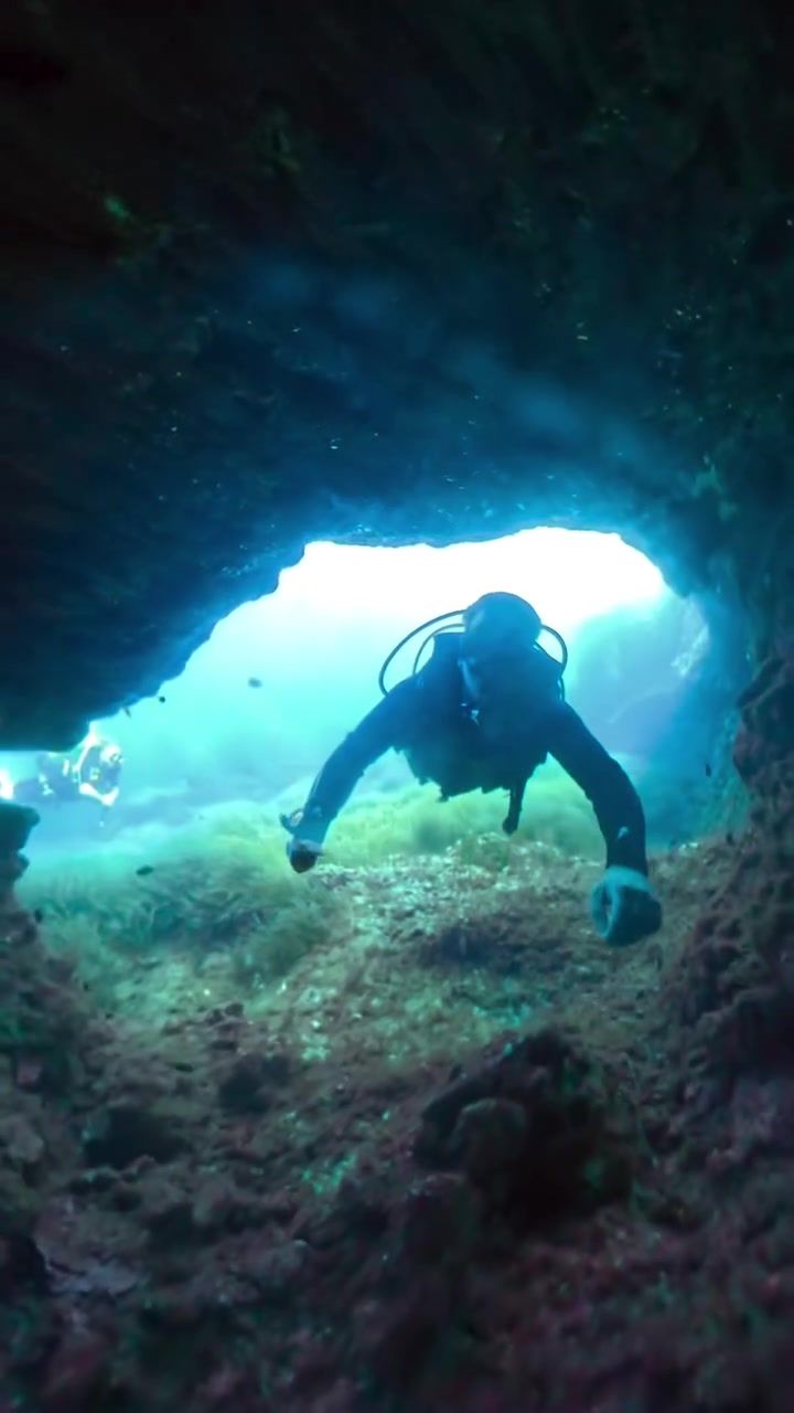 Diving through a cave off Malta, photographed by Si and Beth