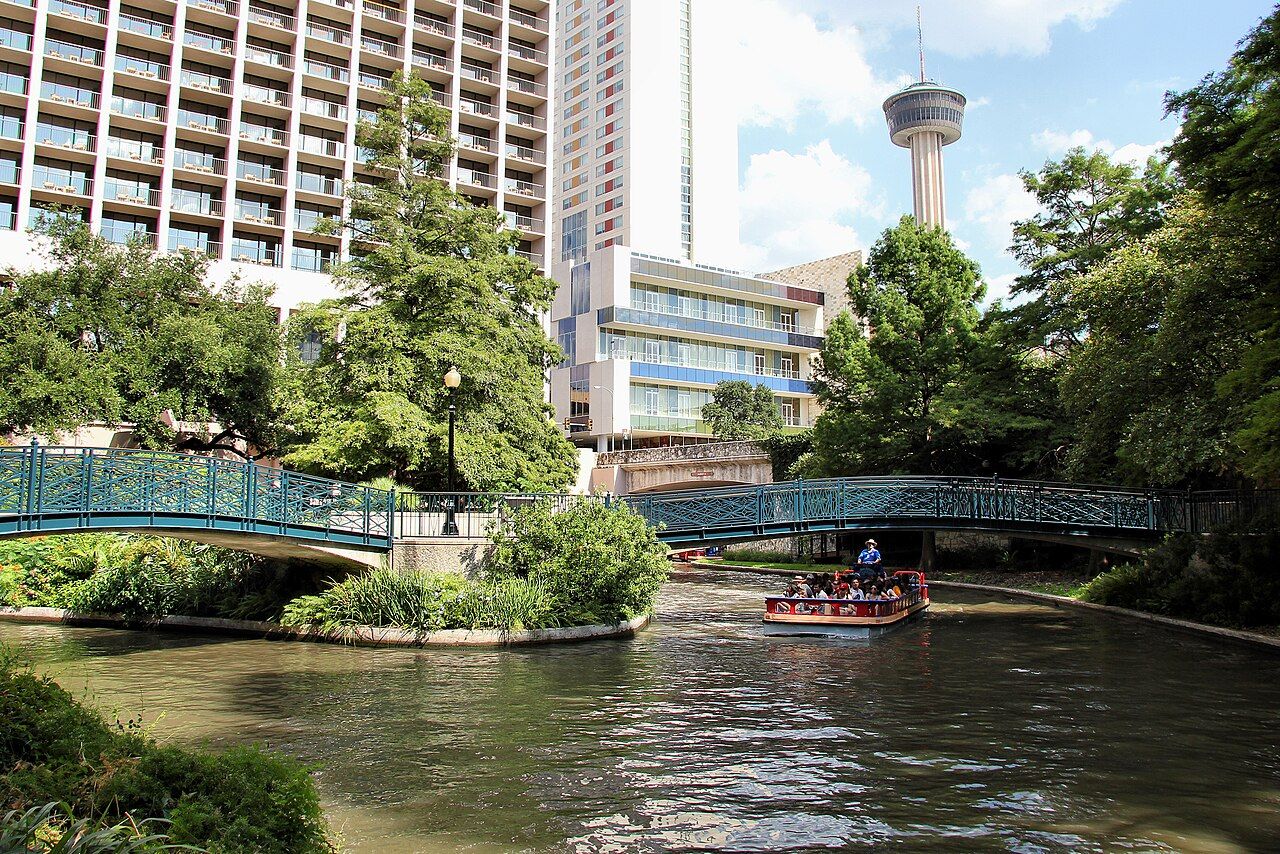 The San Antonio River Walk with the Tower of the Americas in the background in San Antonio, Texas, United States.